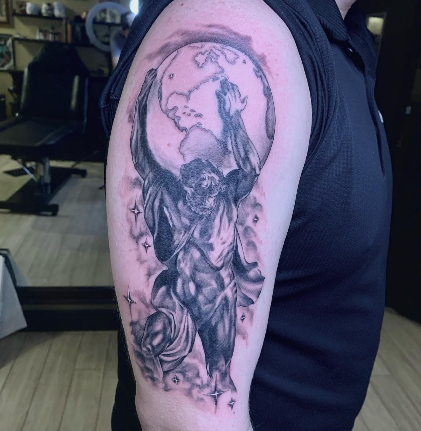 Man carrying globe realism tattoo on the upper arm by Tad Fulkerson, San Francisco, California