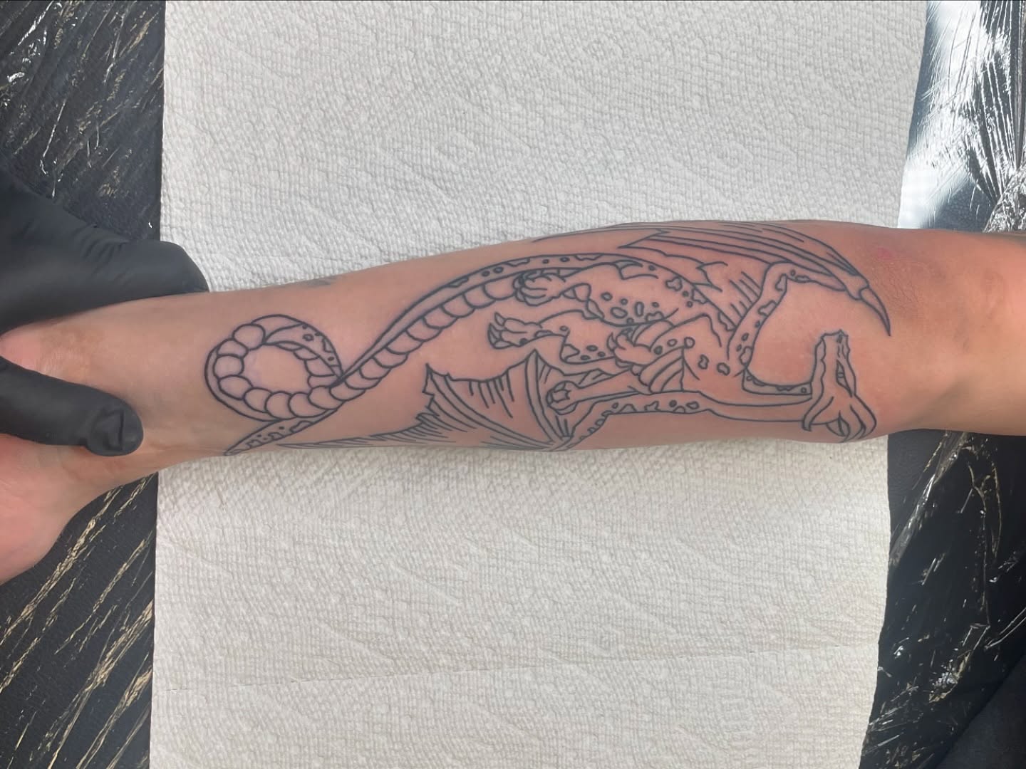 Dragon and snake black and grey tattoo on the forearm by Nyah Ramirez