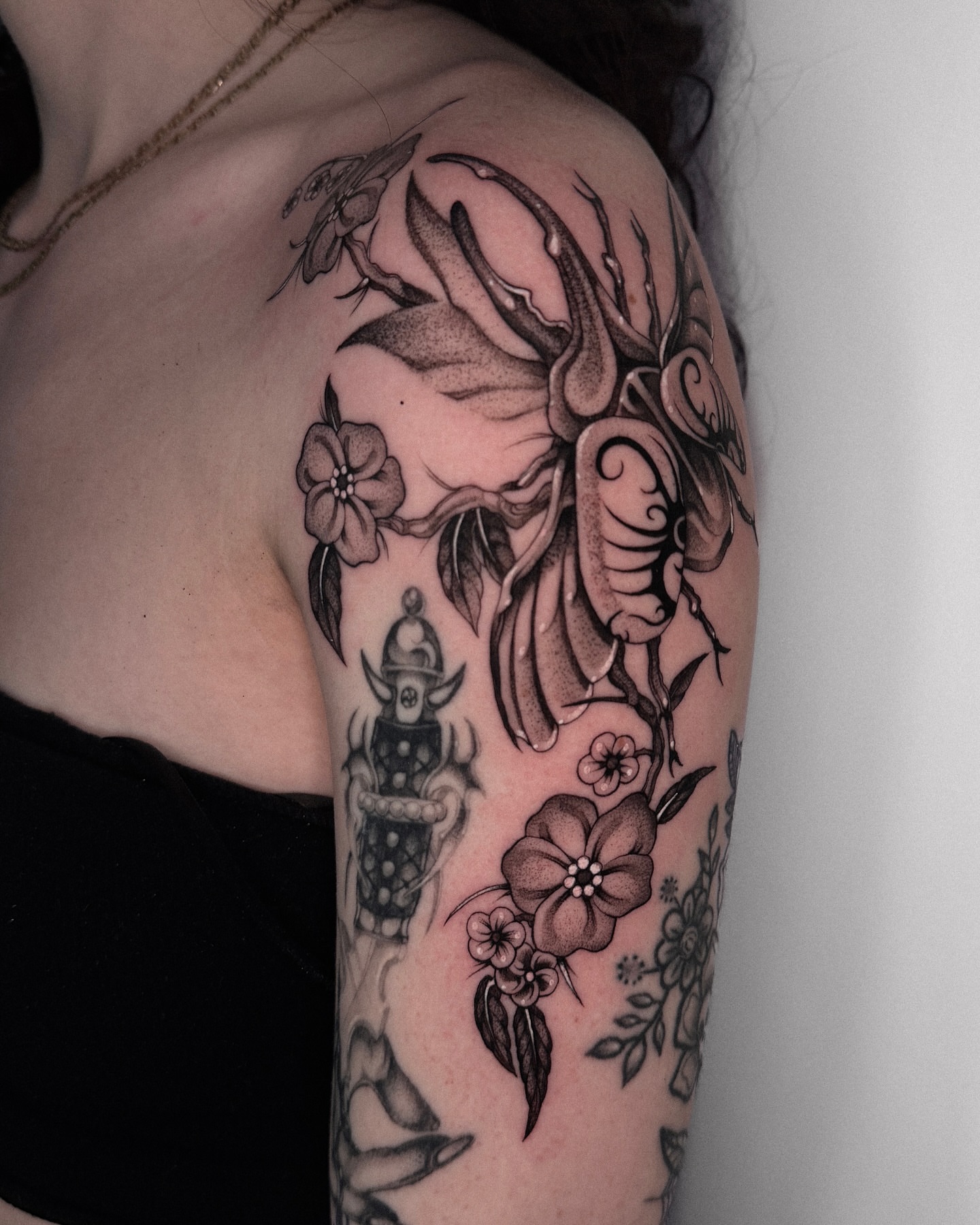 Floral and insect dotwork tattoo on the shoulder by ella