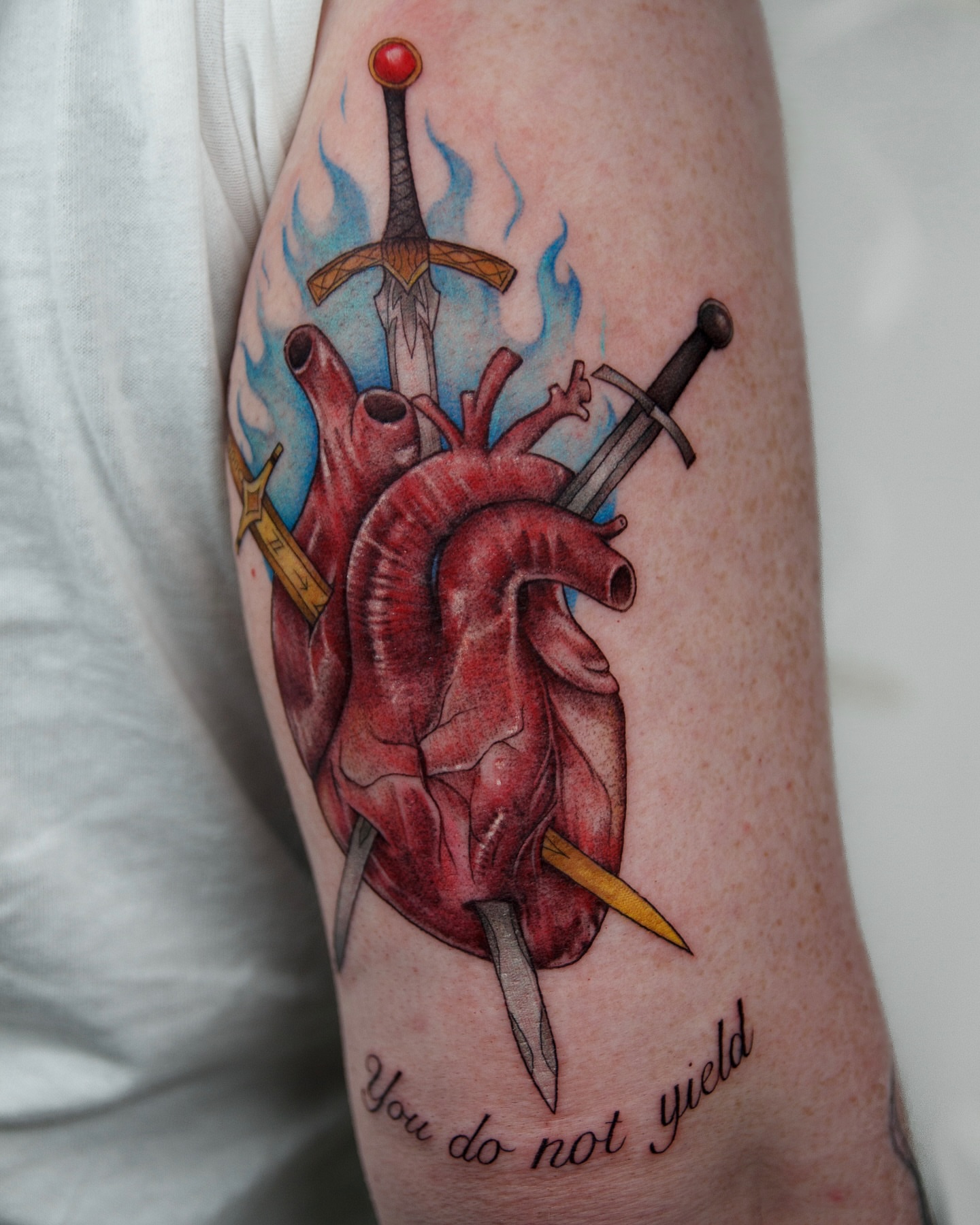 Heart with swords realism tattoo on the forearm by caliope yiannos