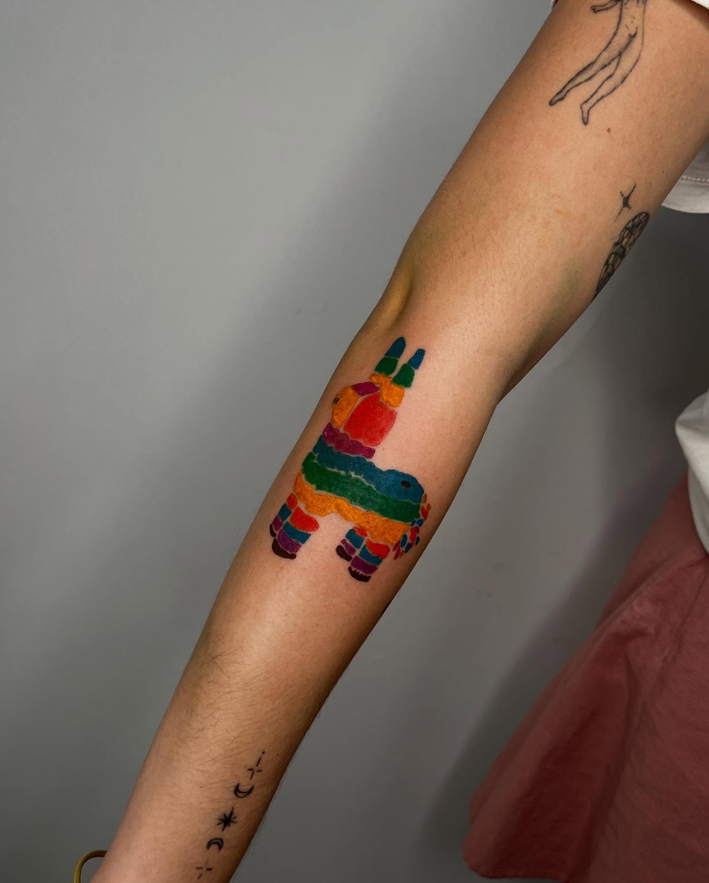 PiΓ±ata new school tattoo on the forearm by tattoos by quin
