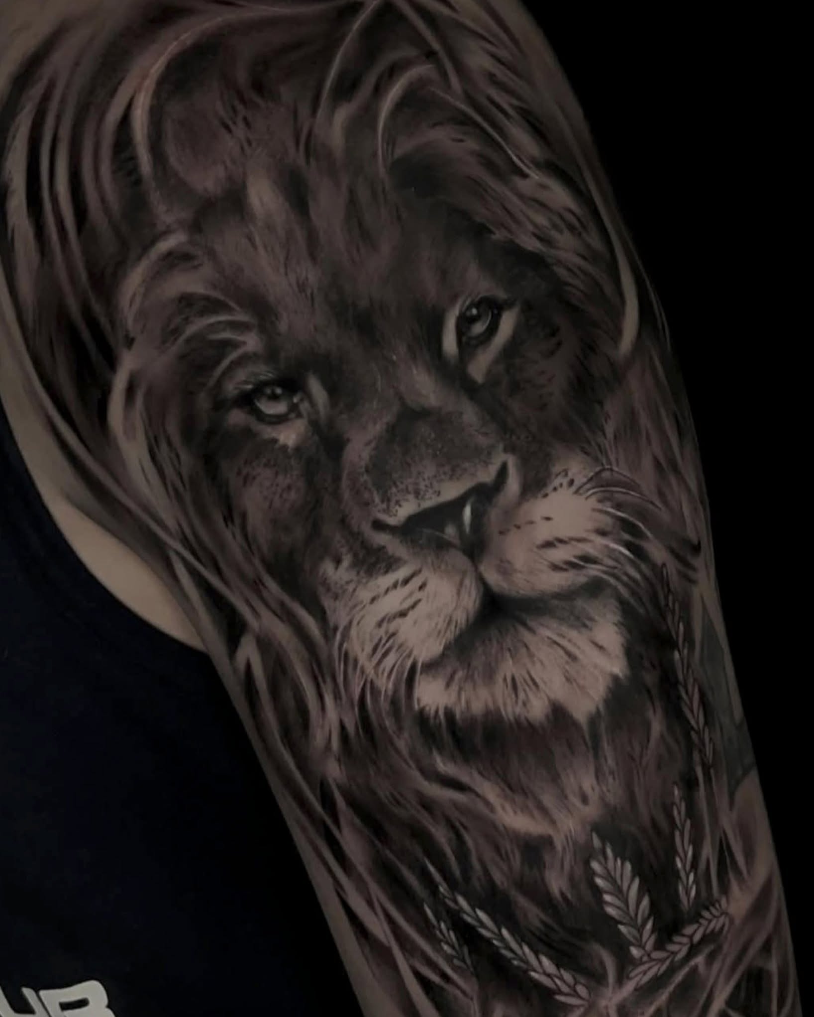 Lion realism tattoo on the upper arm by Diego Andrés Cárdenas