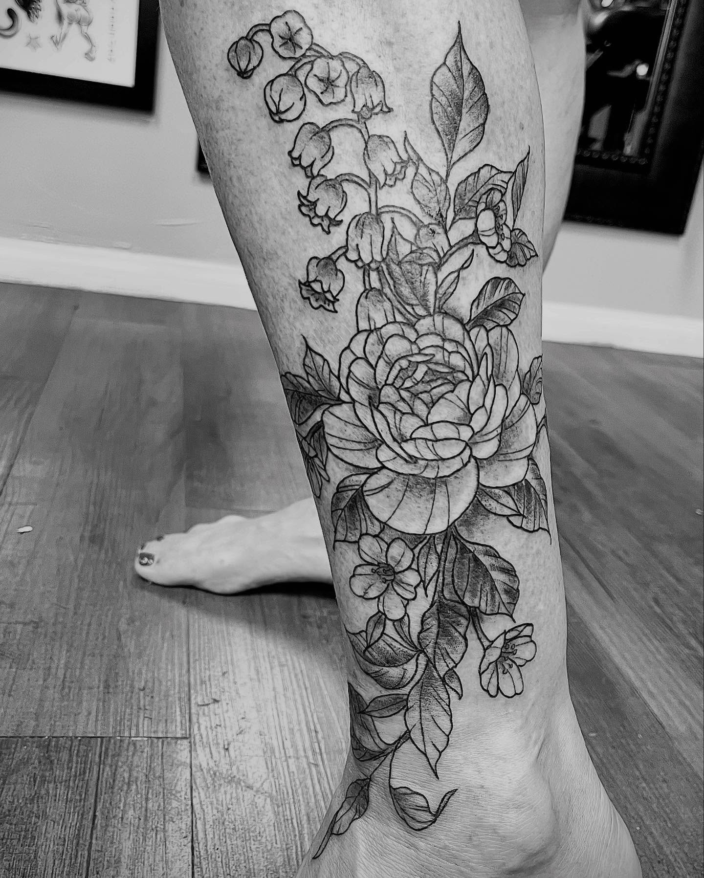 Floral arrangement realism tattoo on the calf by Quality Tattoos done by Kurt