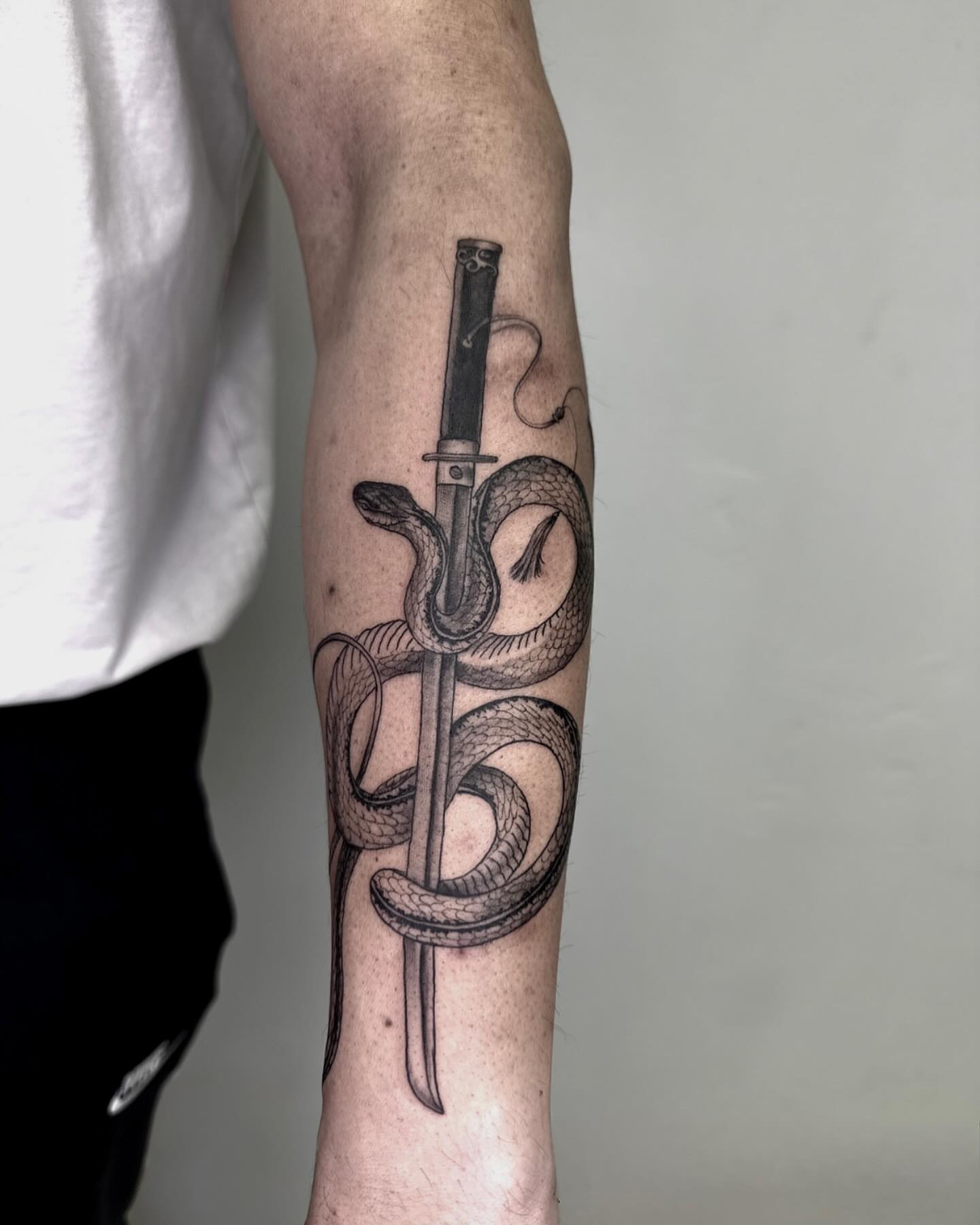 Snake and dagger realism tattoo on the forearm by Rachel