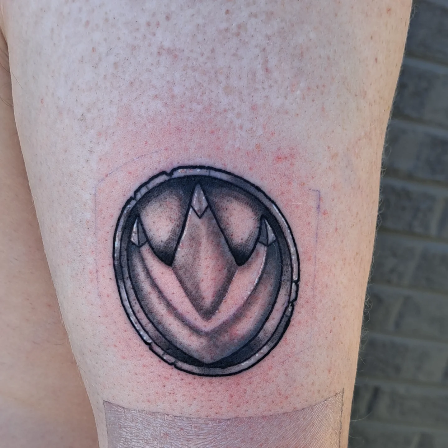 Stylized emblem tattoo on the forearm by Jake Mincey
