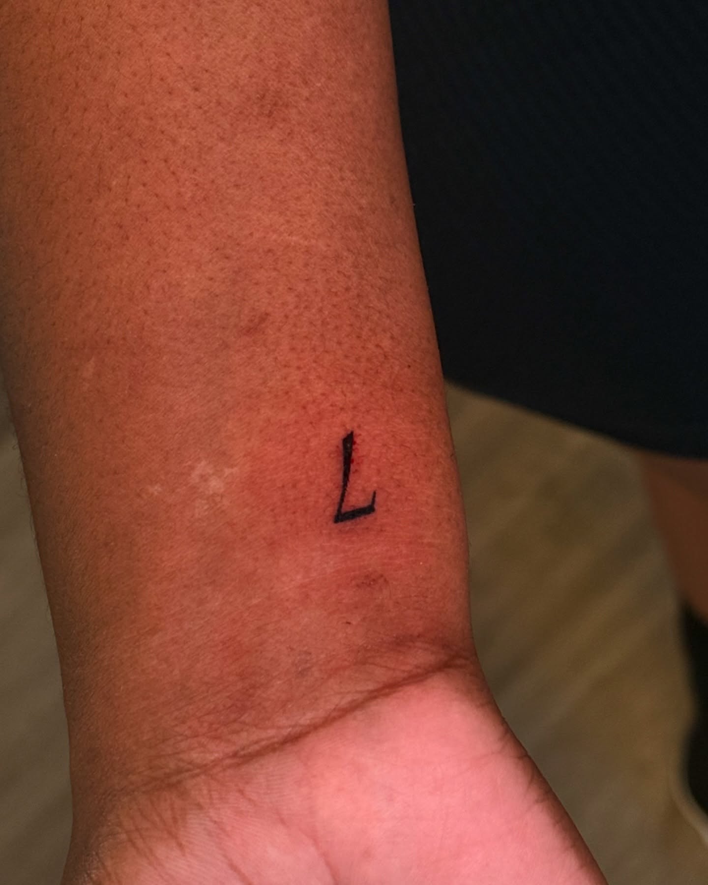 Letter L lettering script tattoo on the forearm by Gabby Finearts