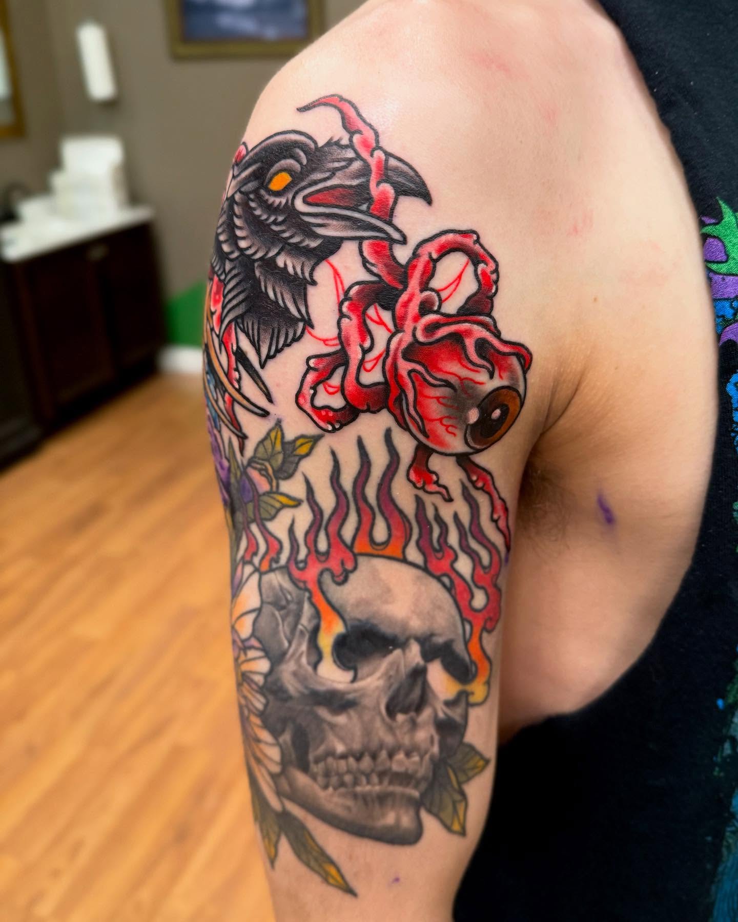 Skull with flames American traditional tattoo on the upper arm by Sam Babcock