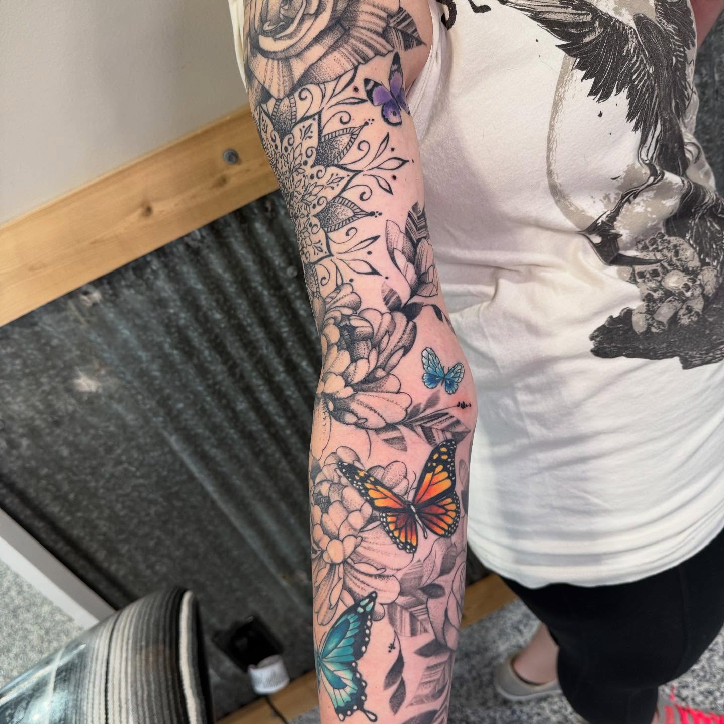 Floral and butterfly new school tattoo on the forearm by Troy Butner