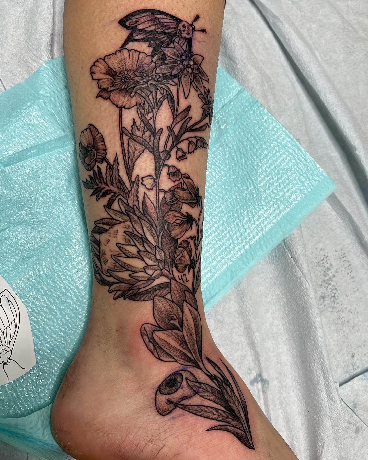 Botanical arrangement black and grey tattoo on the calf by Taya Lynn, Hudson, Wisconsin