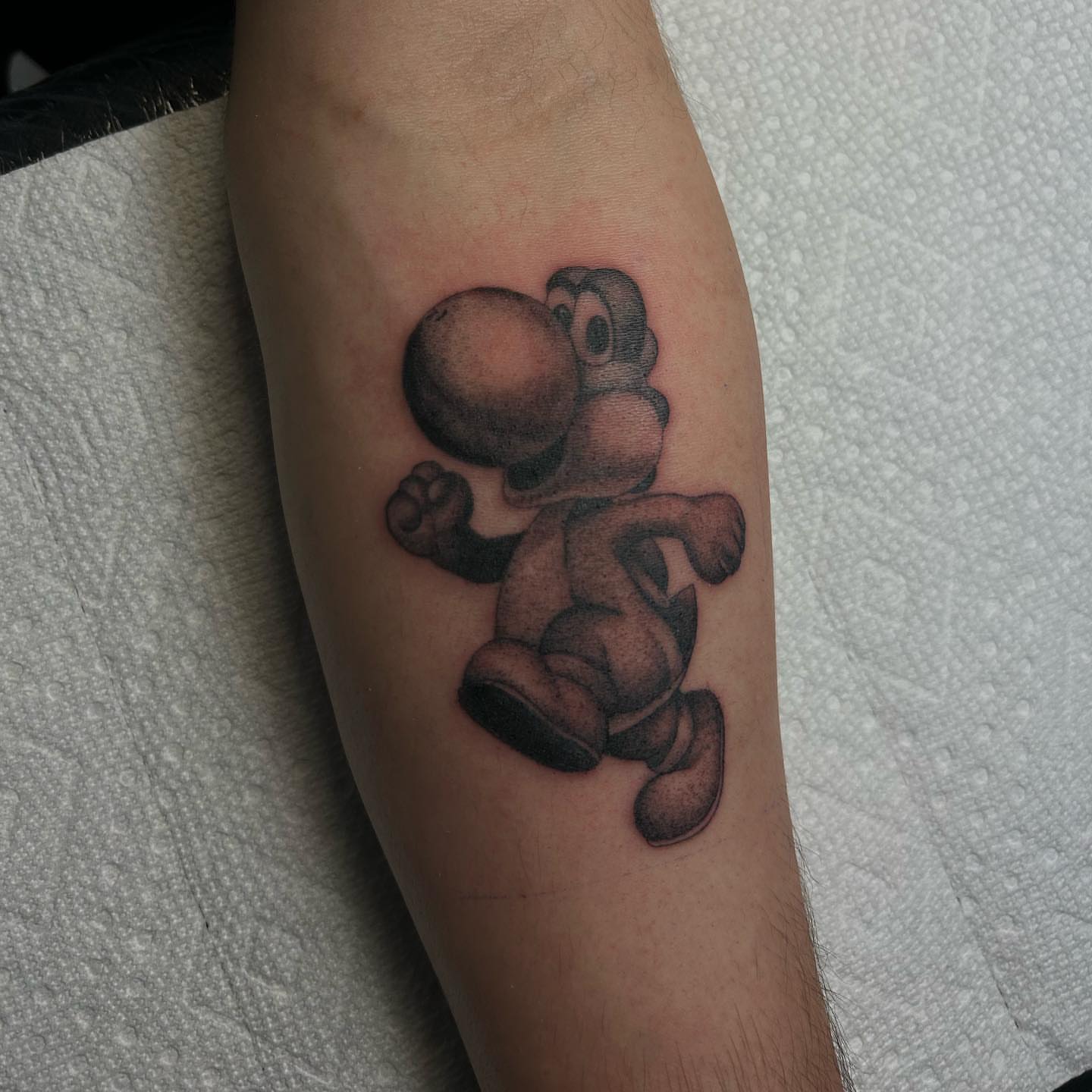 Yoshi black and grey tattoo on the forearm by Alex Lang