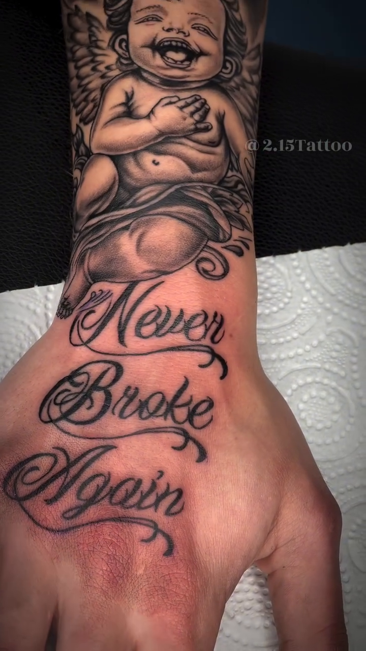 Cherub and lettering sleeve Chicano tattoo on the hand by Tattoo (Réaliste), Toulouse, Occitanie