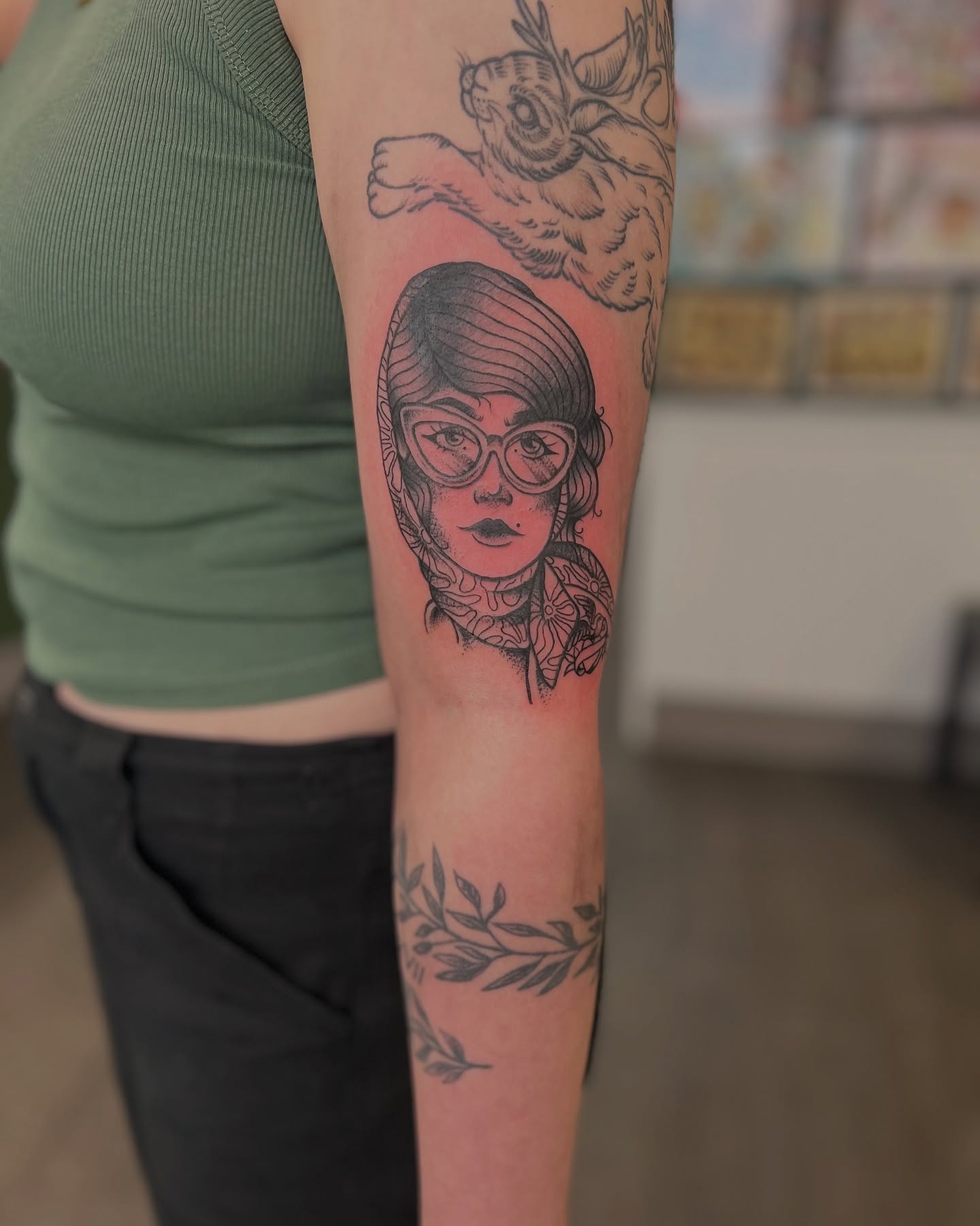 Woman with glasses black and grey tattoo on the forearm by Luna Faye
