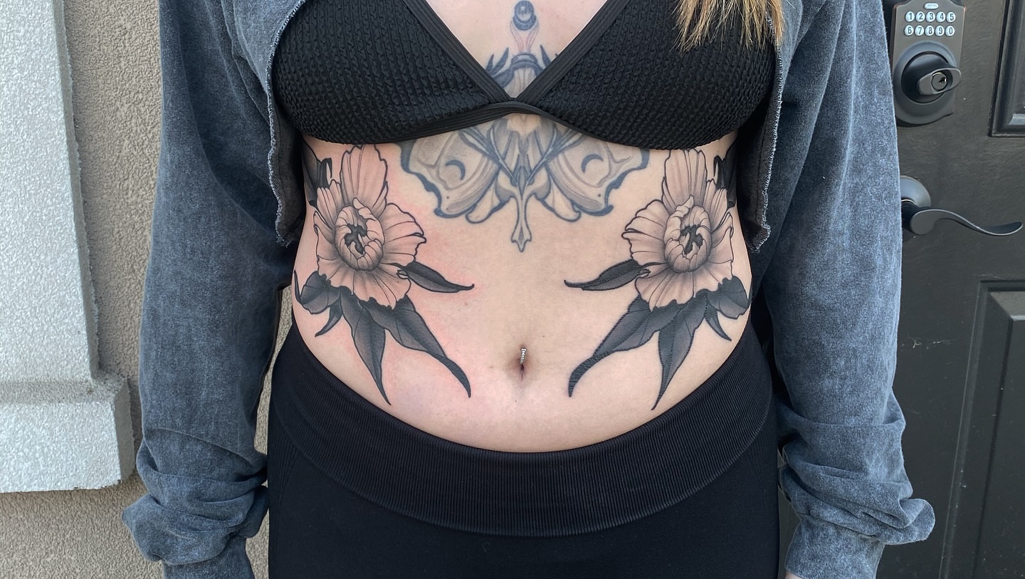 Floral black and grey tattoo on the torso by Jake Kirk