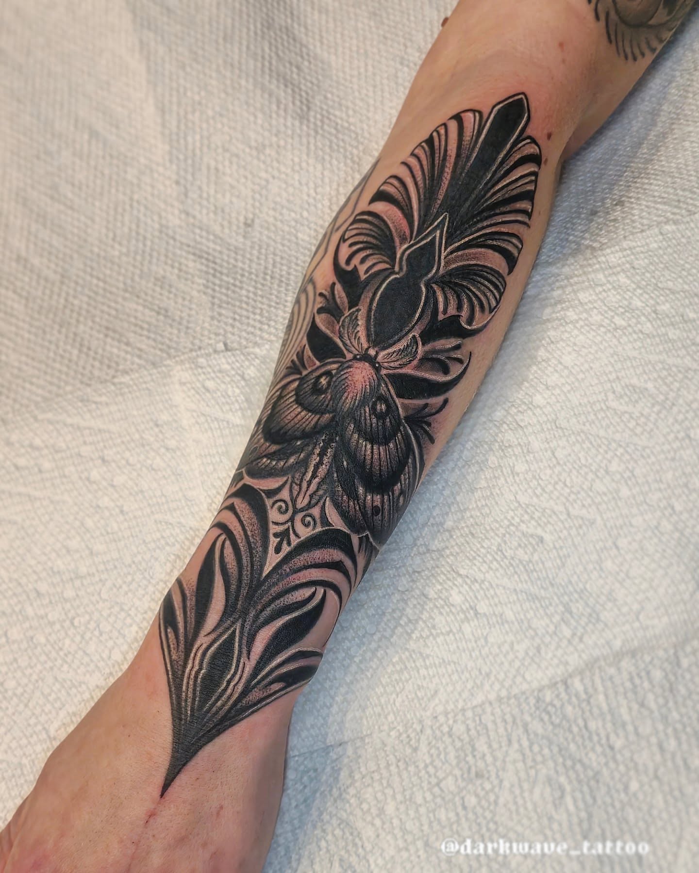 Floral design black and grey tattoo on the forearm by Barrett Handel