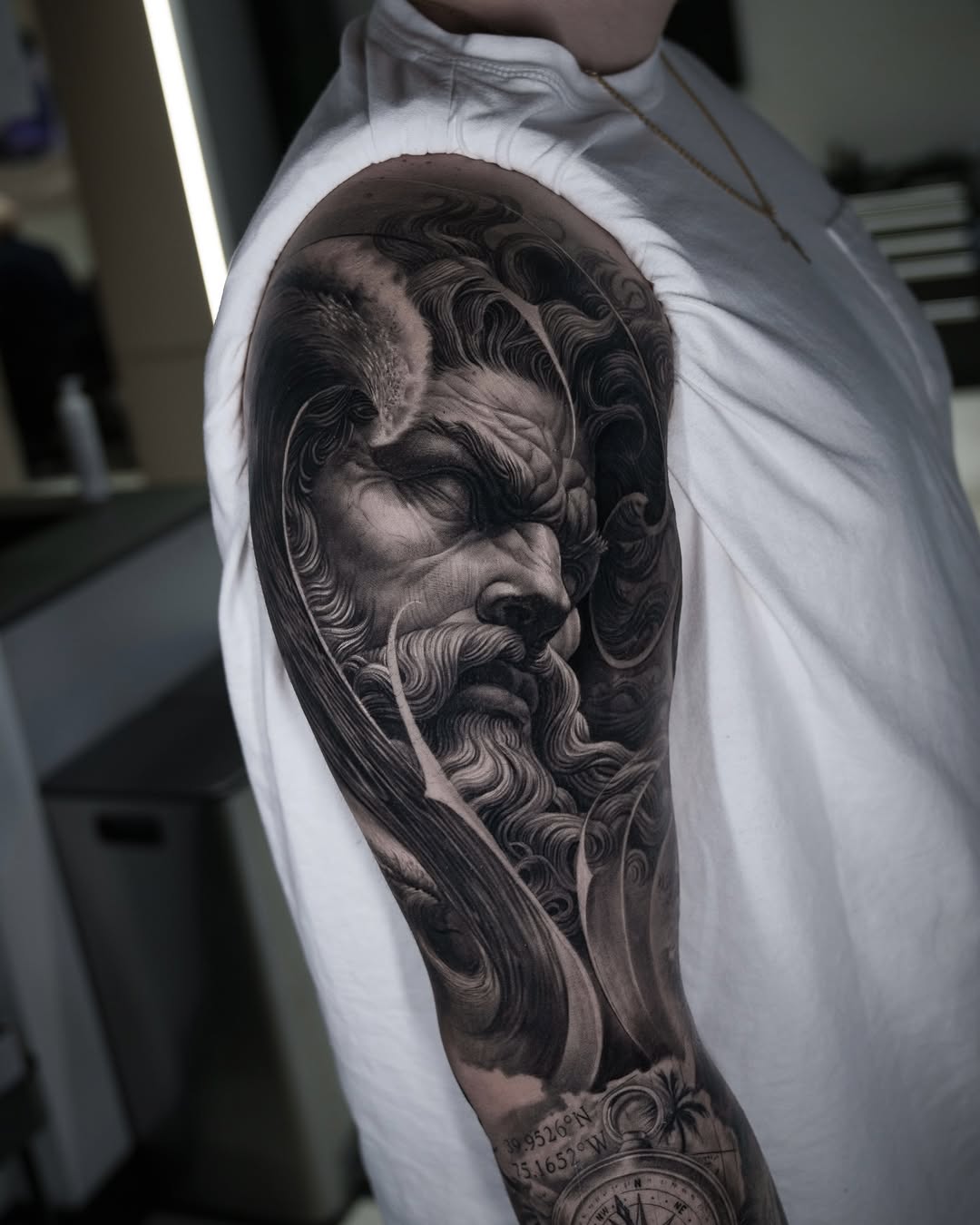 Man's face and compass realism tattoo on the upper arm by @_garart_