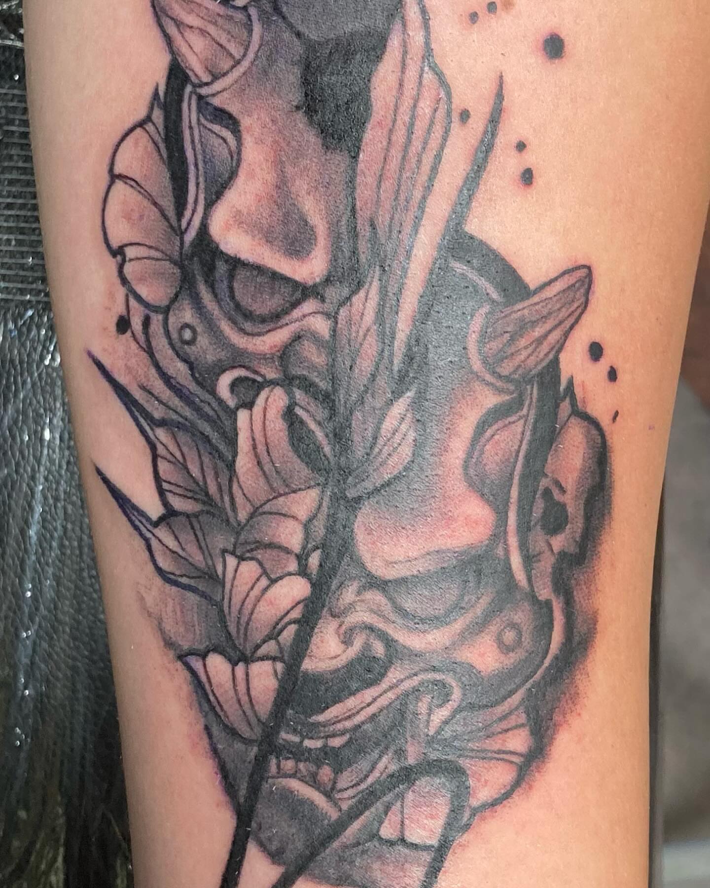 Mask and flowers realism tattoo on the forearm by Hot Dawg