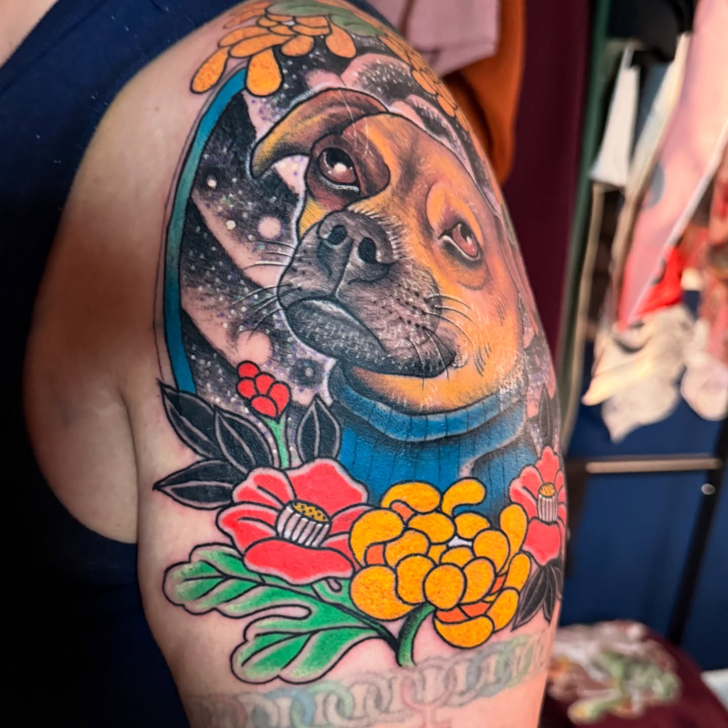 Dog with floral elements American traditional tattoo on the upper arm by Jhon
