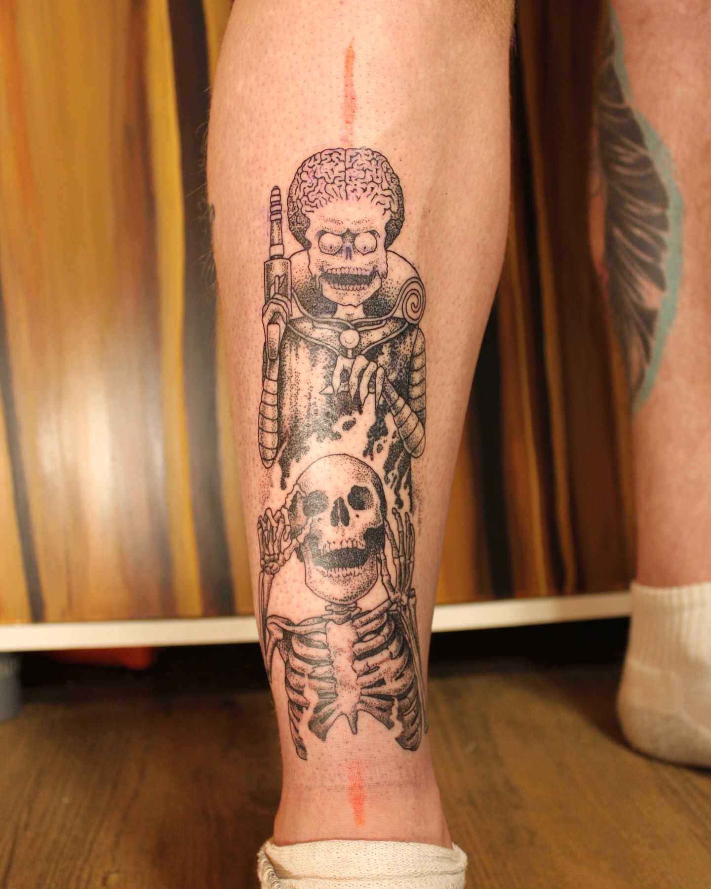 Skeleton and skull black and grey tattoo on the calf by Bombay Pain Co.