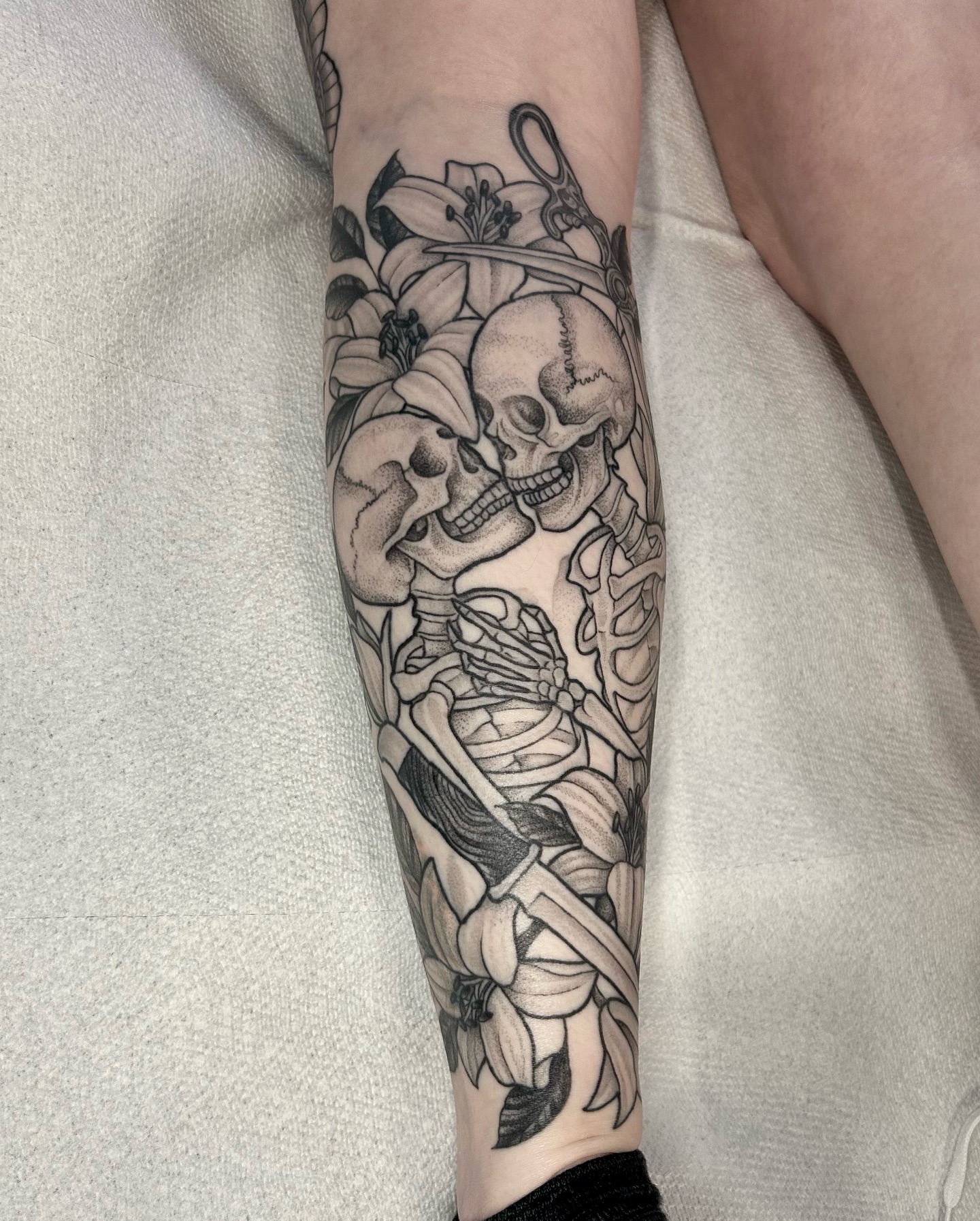 Skulls and lilies realism tattoo on the forearm by 𝔍𝔢𝔫𝔫𝔦𝔢 𝔗𝔦𝔢𝔰𝔪𝔞𝔫