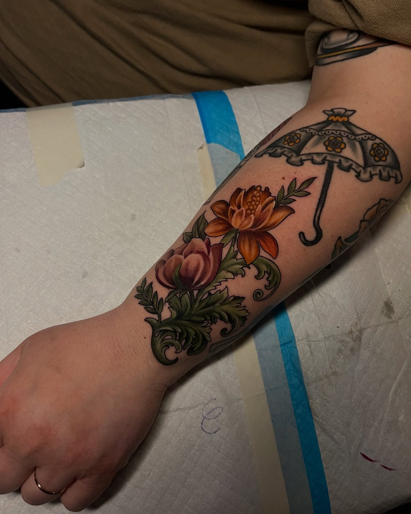 Umbrella and flowers American traditional tattoo on the forearm by Brittany Welsh, Marlton, New Jersey