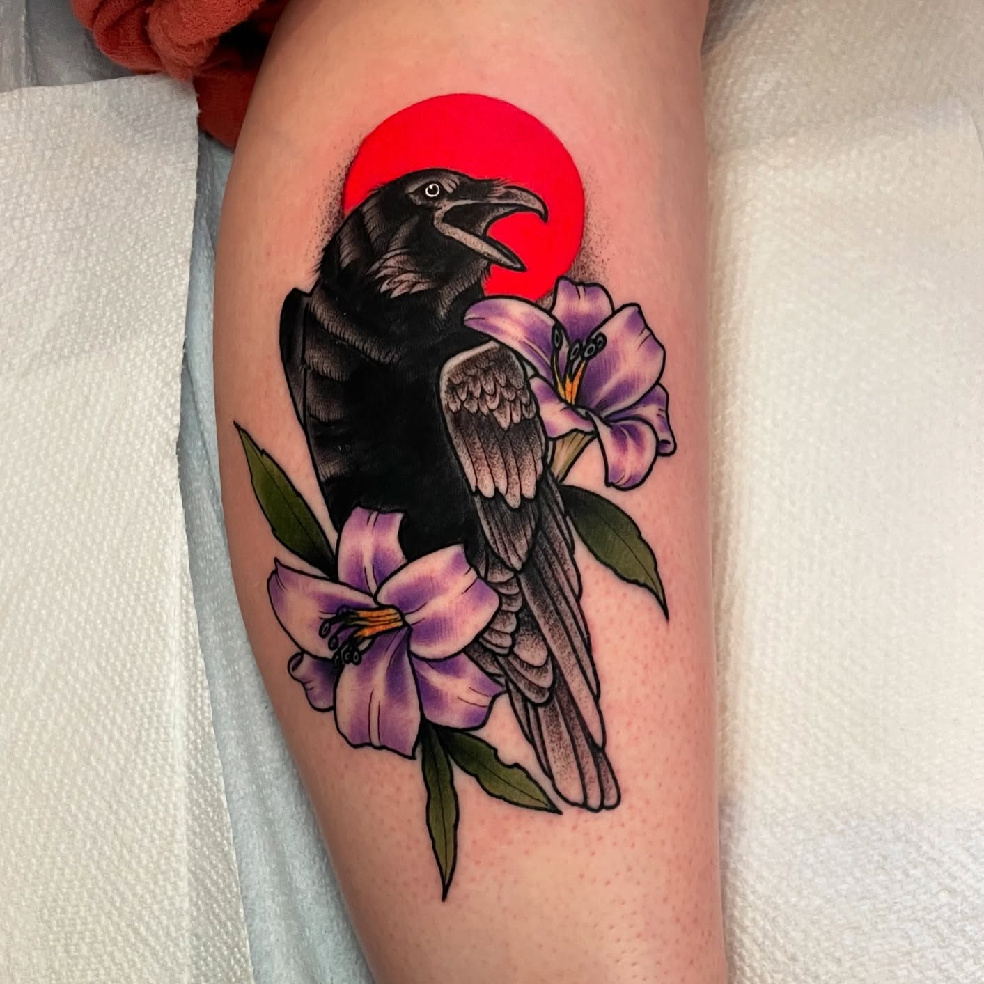 Crow and flowers realism tattoo on the thigh by Ian Spong