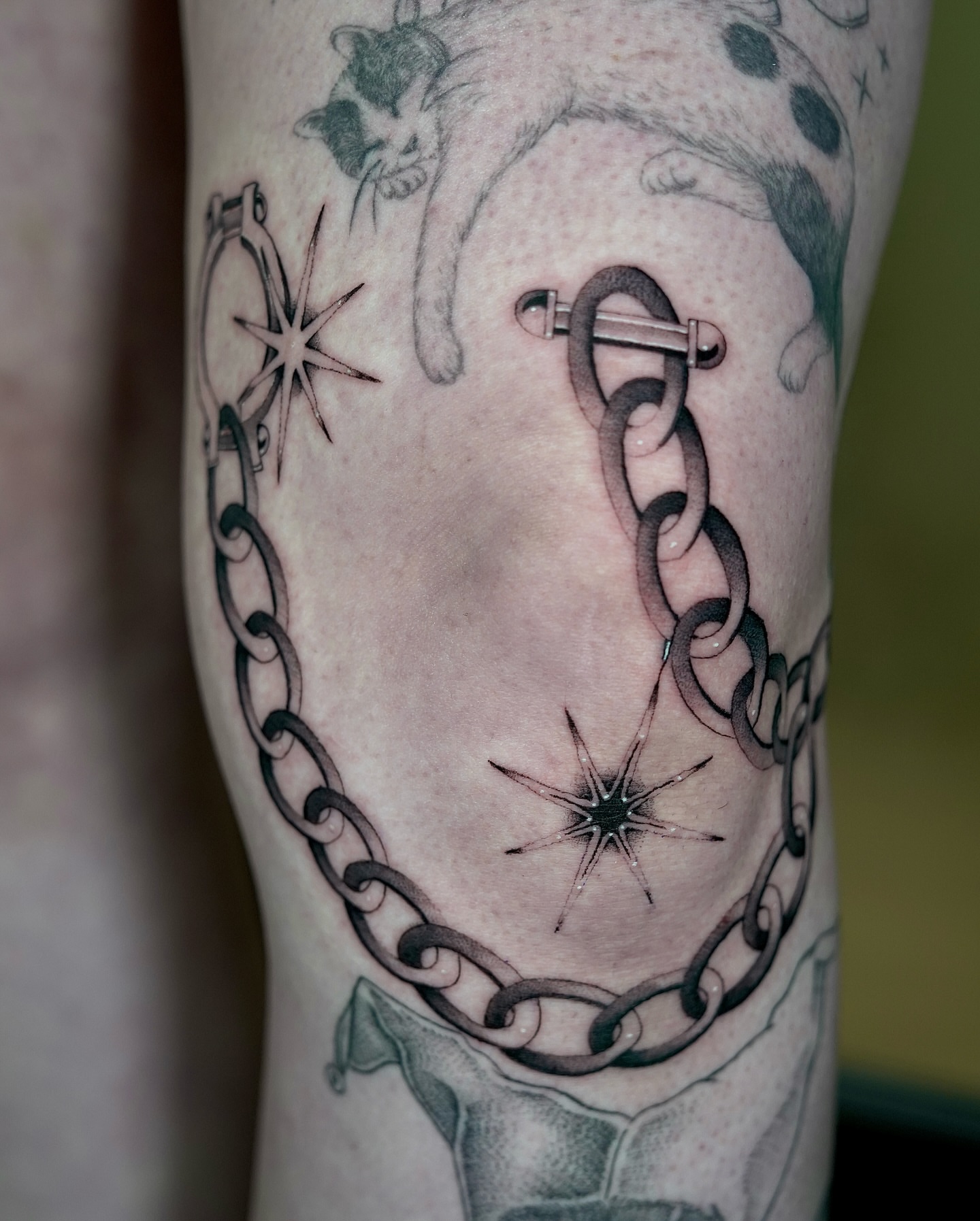 Chain and stars black and grey tattoo on the forearm by Fine line tattoo San Diego, San Diego, California