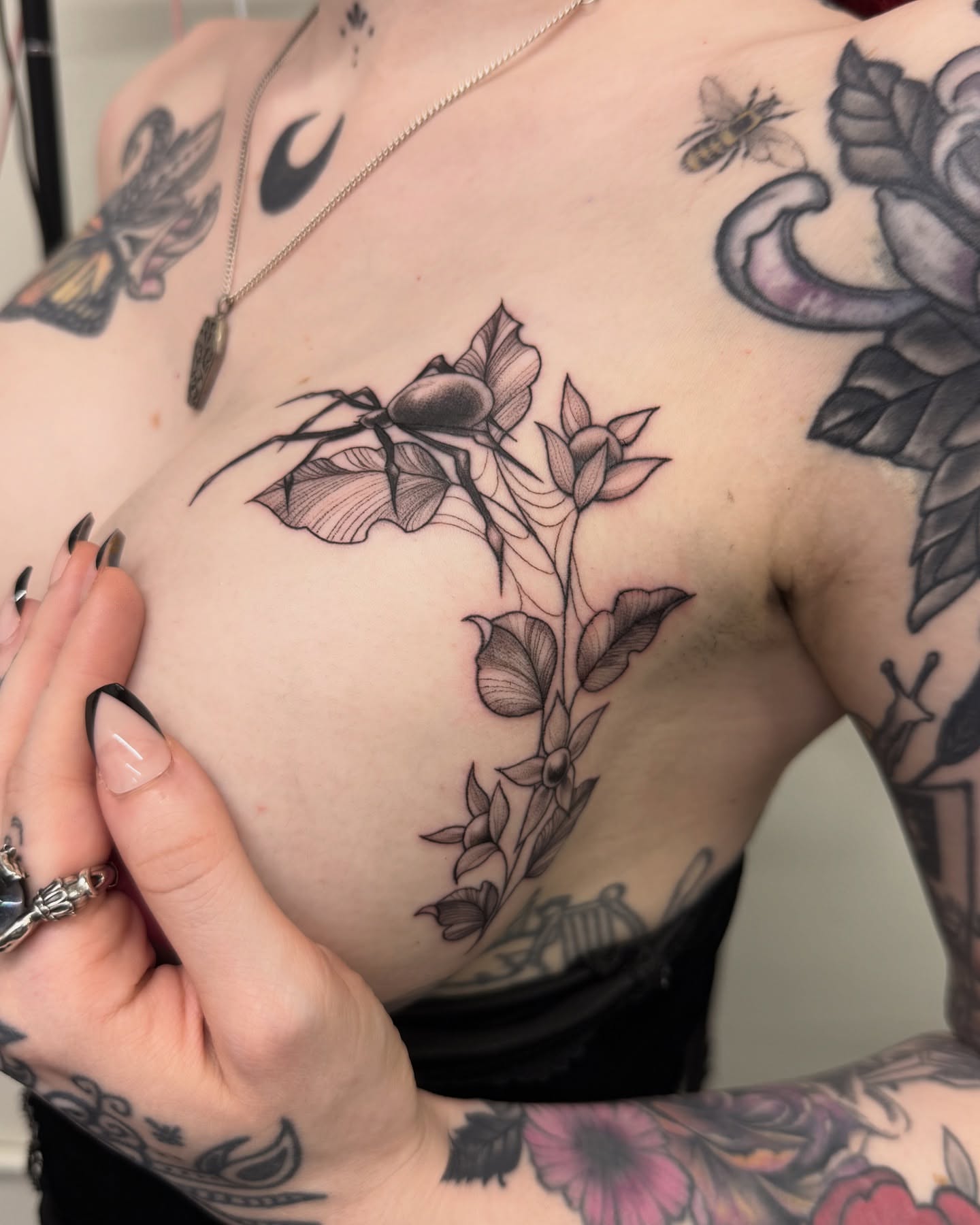 Flower and spider black and grey tattoo on the chest by liliana lopez
