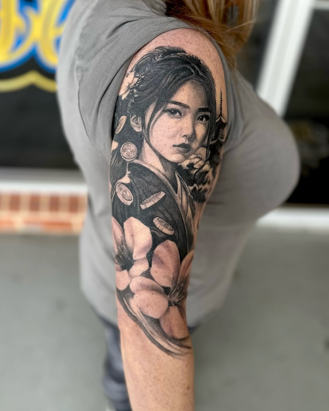 Realism tattoo on the upper arm by Maggie George