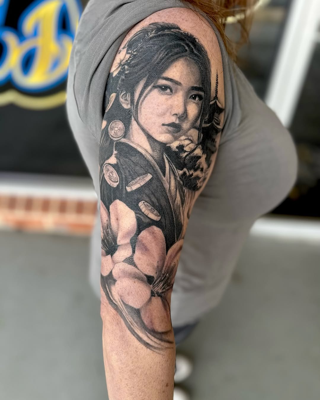 Geisha portrait with flowers and coins realism tattoo on the forearm by Maggie George
