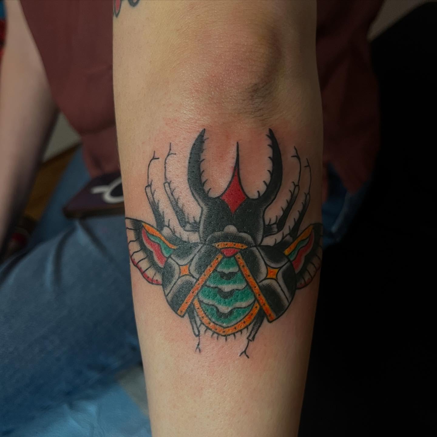 Beetle American traditional tattoo on the forearm by Mariah Nguyen
