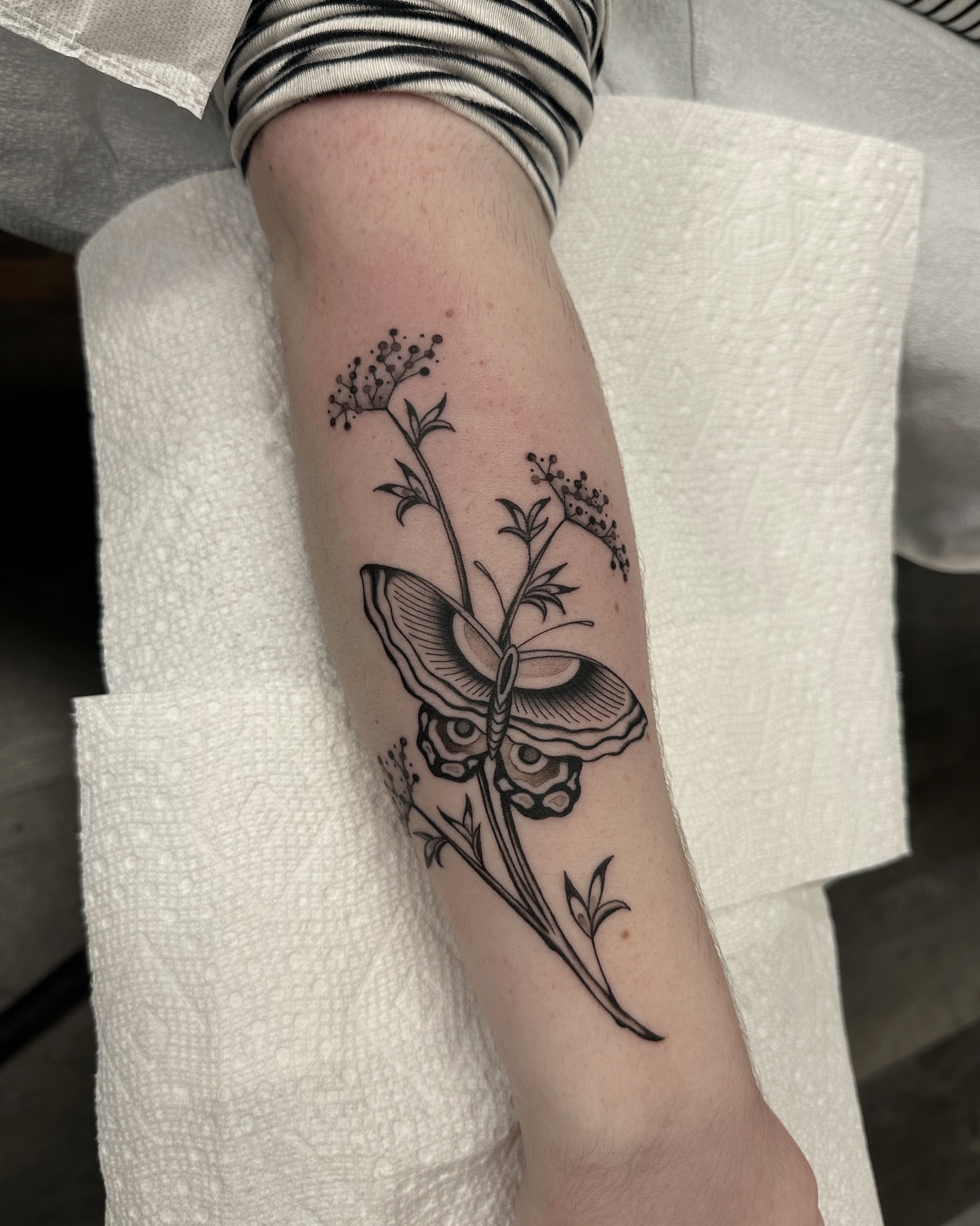Butterfly and flowers black and grey tattoo on the forearm by Nicholas Lee, San Francisco, California