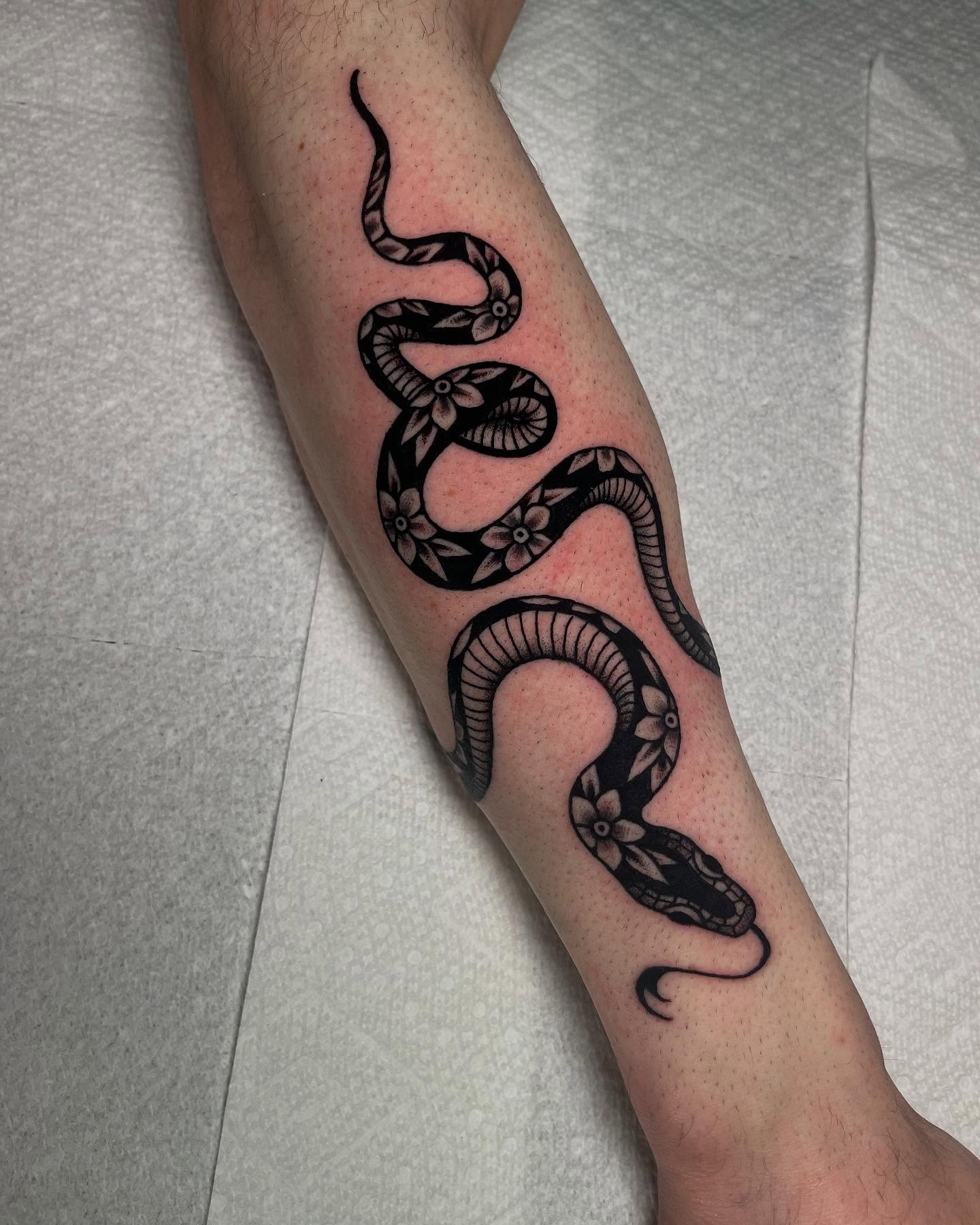 Snake black and grey tattoo on the forearm by Marqui Watling