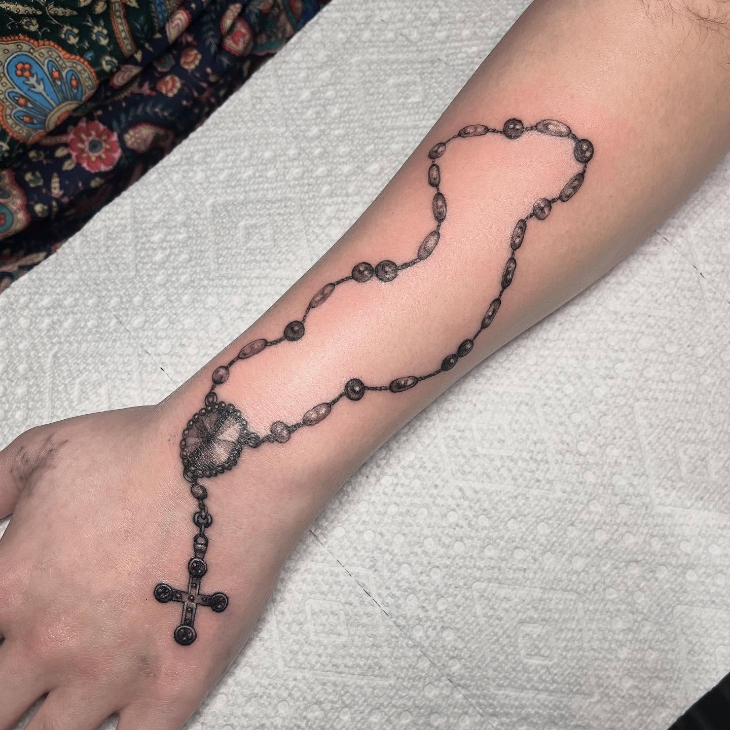 Rosary black and grey tattoo on the forearm by aurora