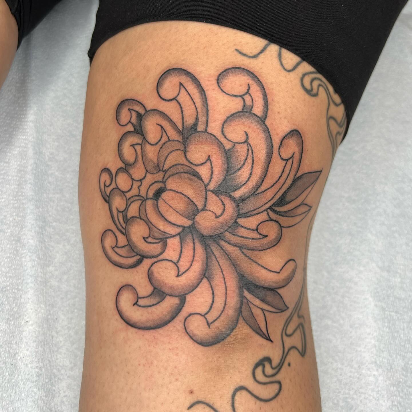 Chrysanthemum American traditional tattoo on the thigh by Robb Wilson