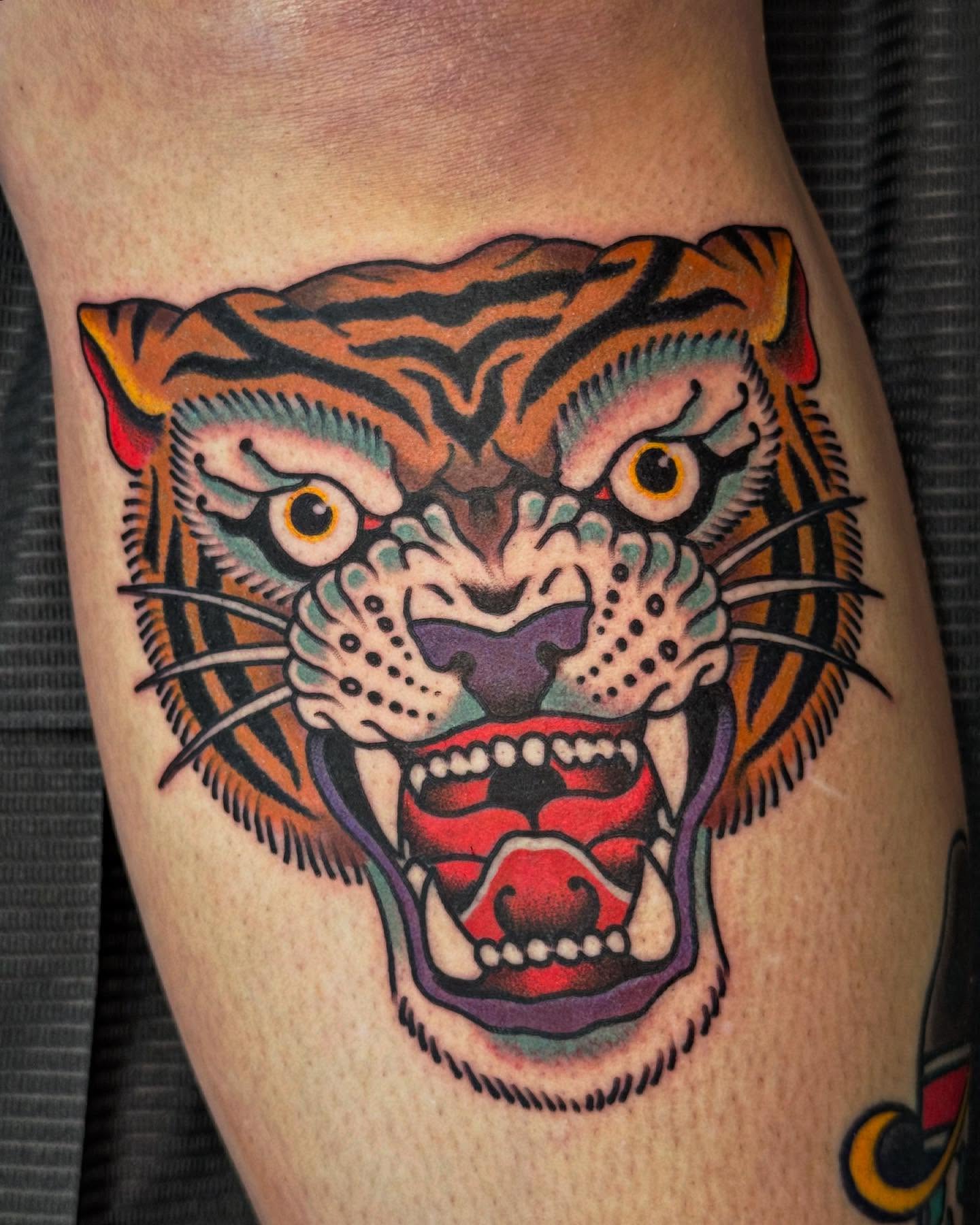 Roaring tiger American traditional tattoo on the thigh by Big Al