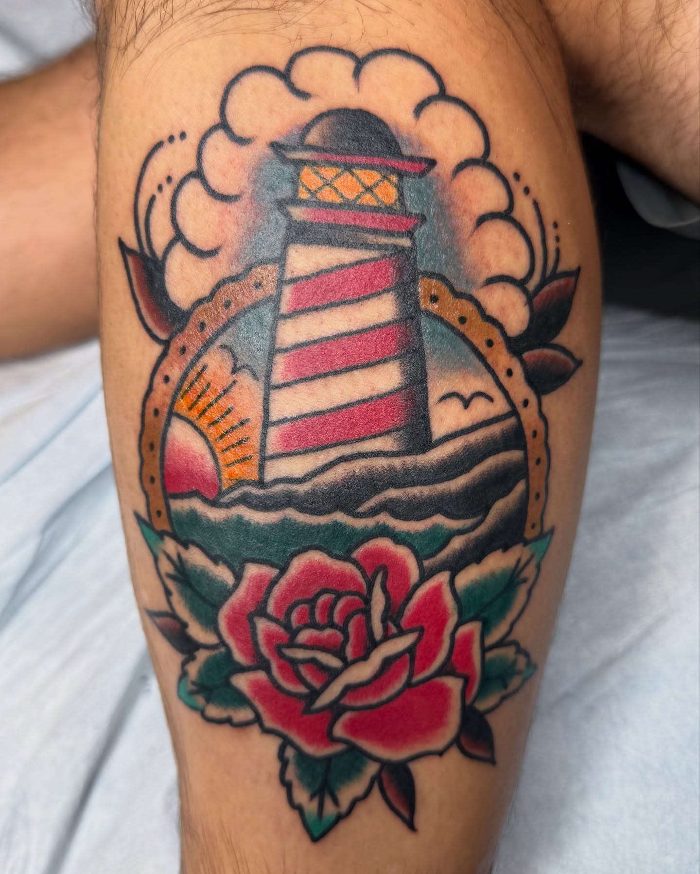 Lighthouse and rose American traditional tattoo on the thigh by DemianThompson