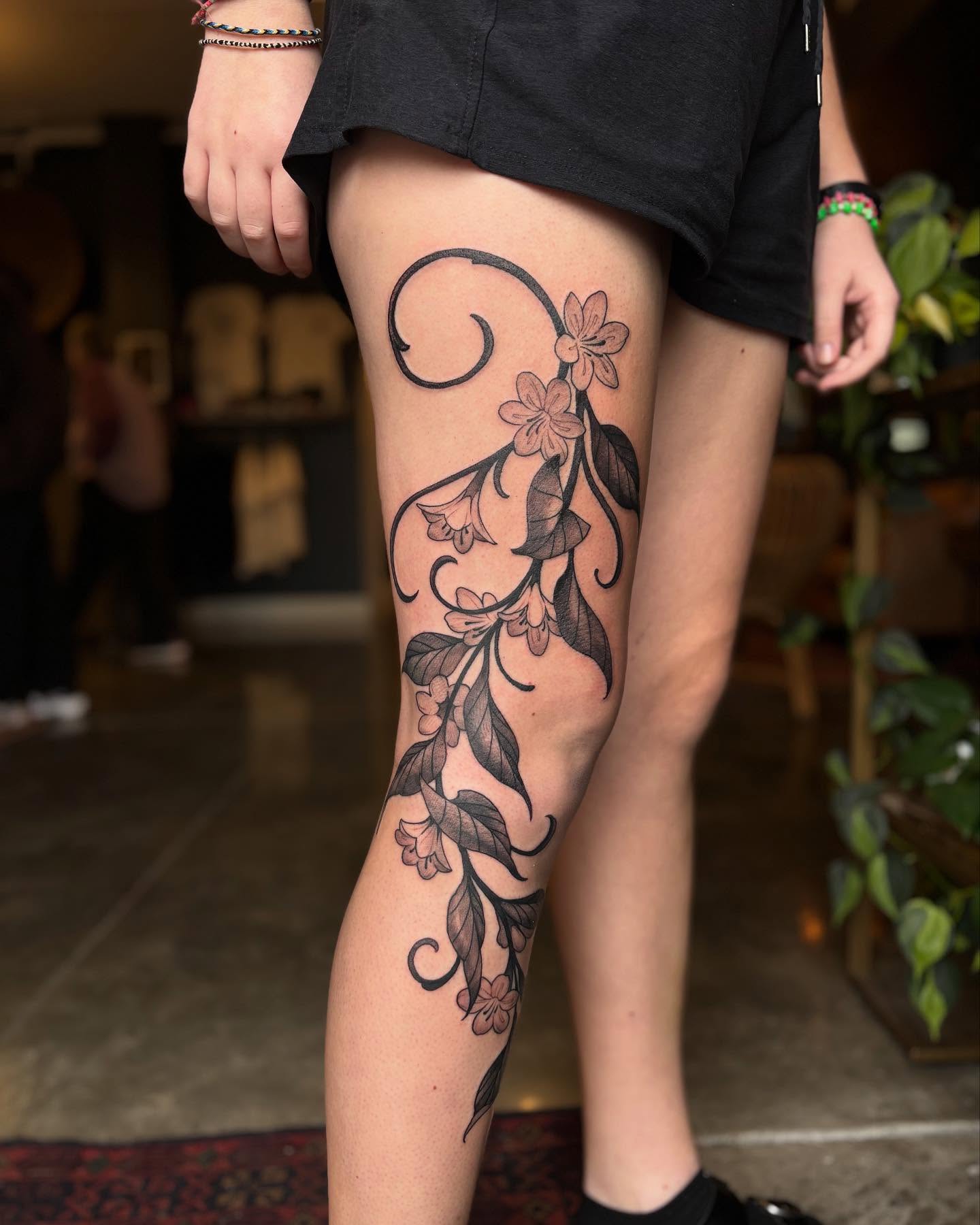 Floral vine black and grey tattoo on the thigh by Ian White