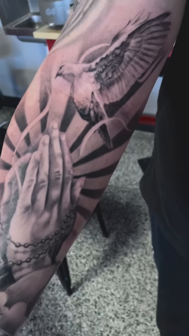 Praying hands with dove Chicano tattoo on the forearm by Jonathan Red