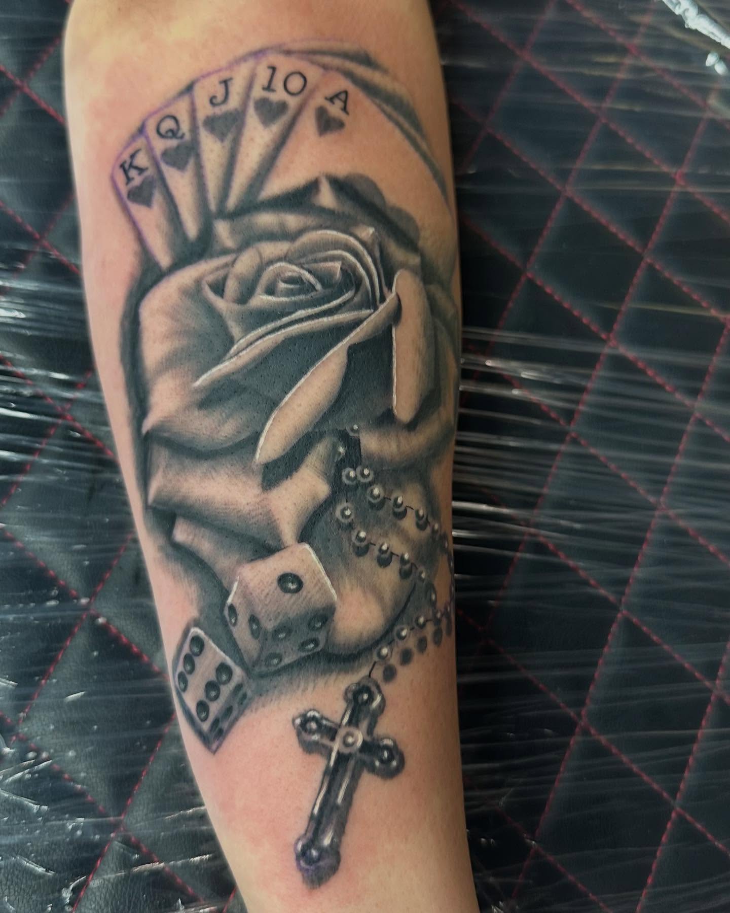 Royal flush and rose realism tattoo on the forearm by Bobby Hurst