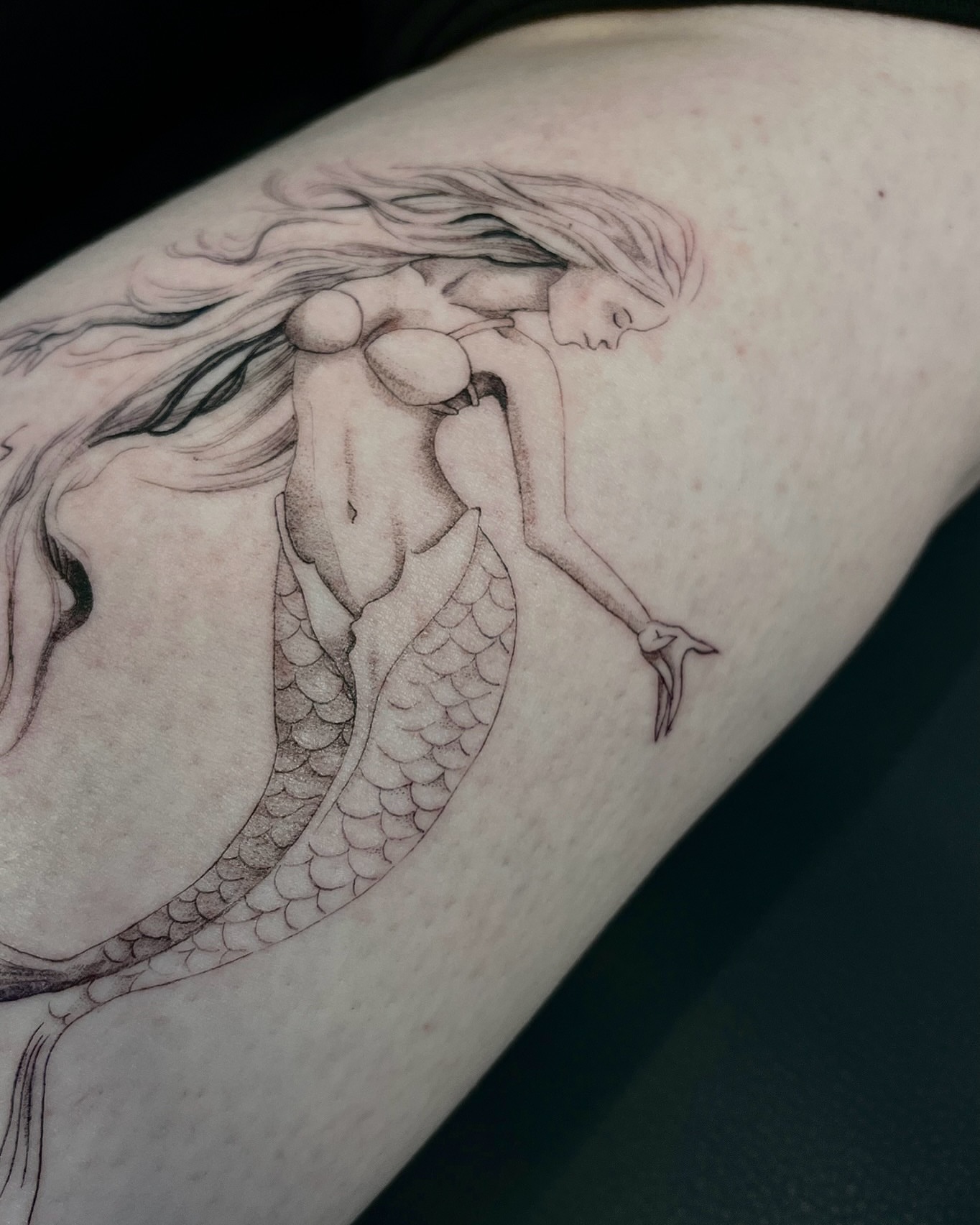 Mermaid black and grey tattoo on the upper arm by Samantha