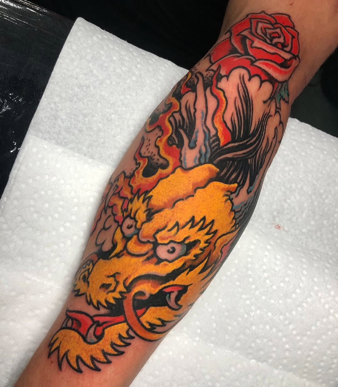 Dragon and rose American traditional tattoo on the forearm by Gabi Elia
