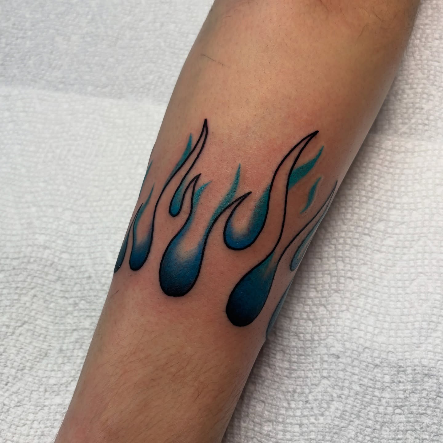Flames new school tattoo on the forearm by Dyllan Shipley