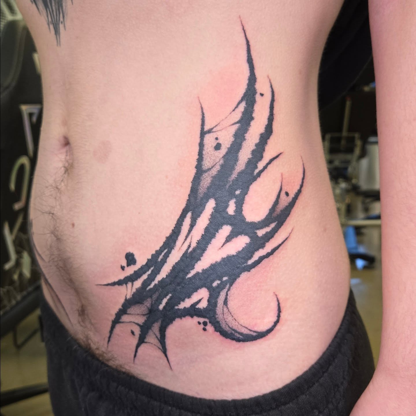 Claw black and grey tattoo on the ribs by Kylie