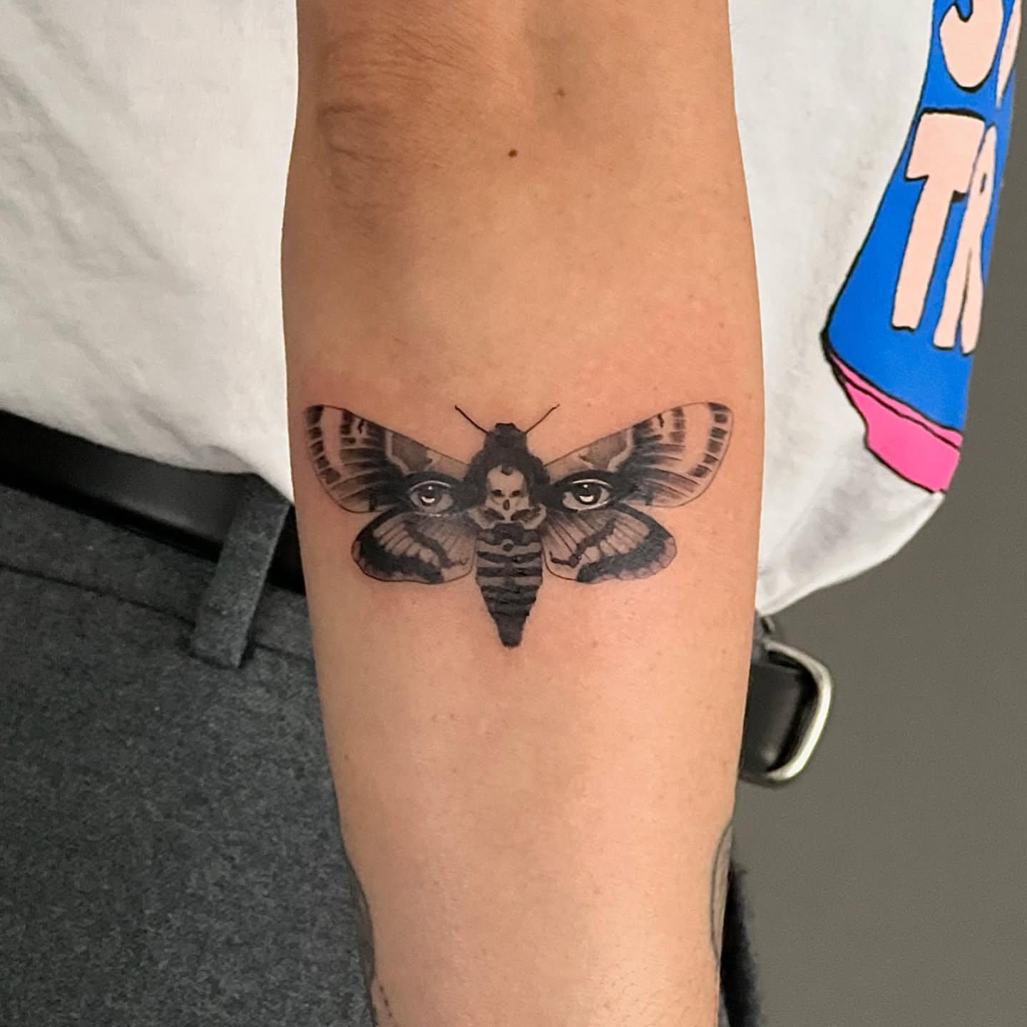 Moth black and grey tattoo on the forearm by Riki