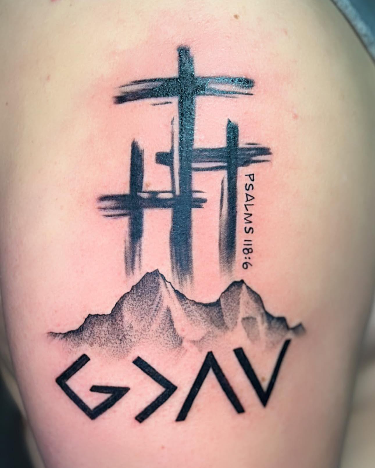 Crosses and mountain black and grey tattoo on the thigh by Nathan Froehlich