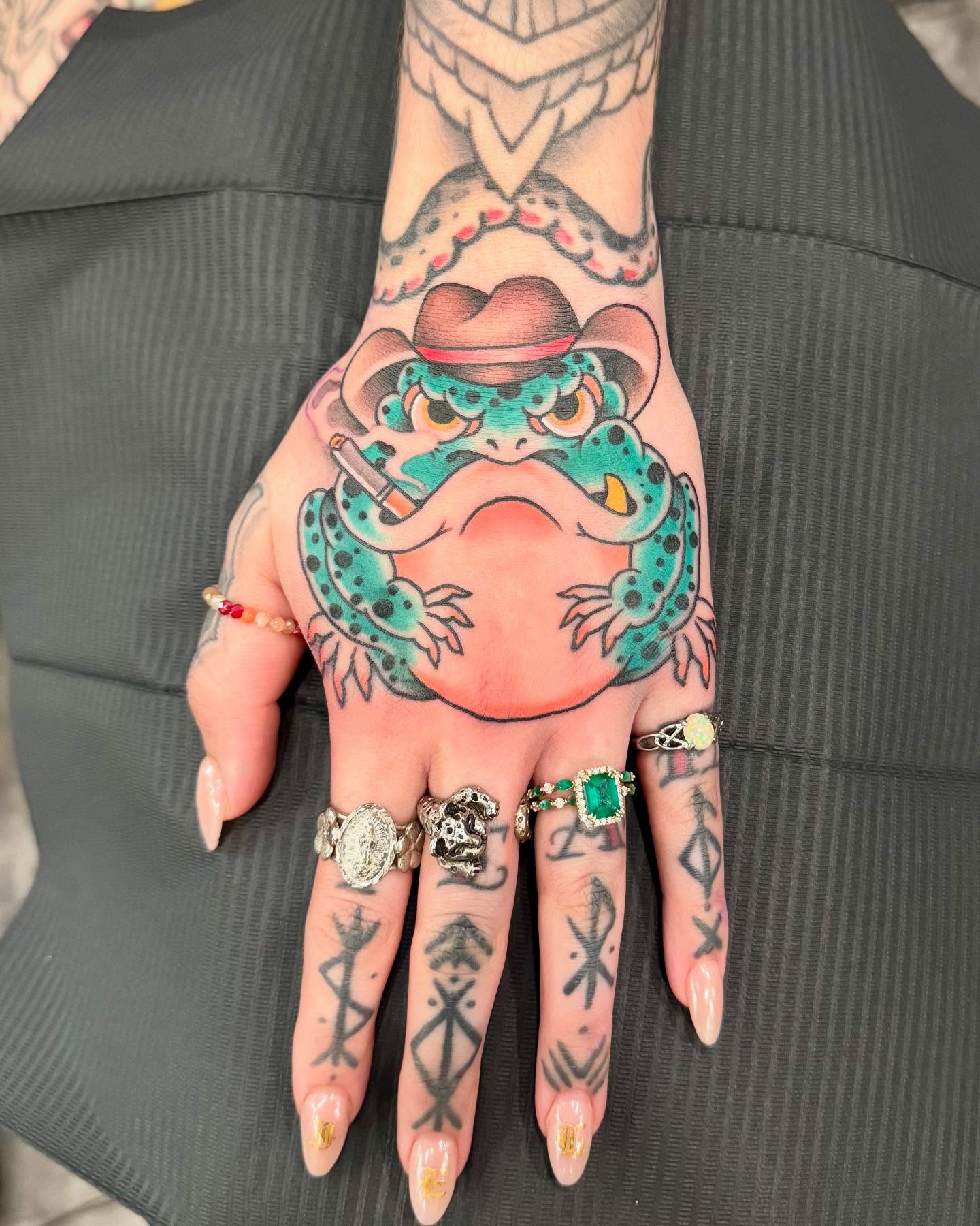 Frog wearing cowboy hat American traditional tattoo on the hand by Jay Espinoza-AZ Tattooer