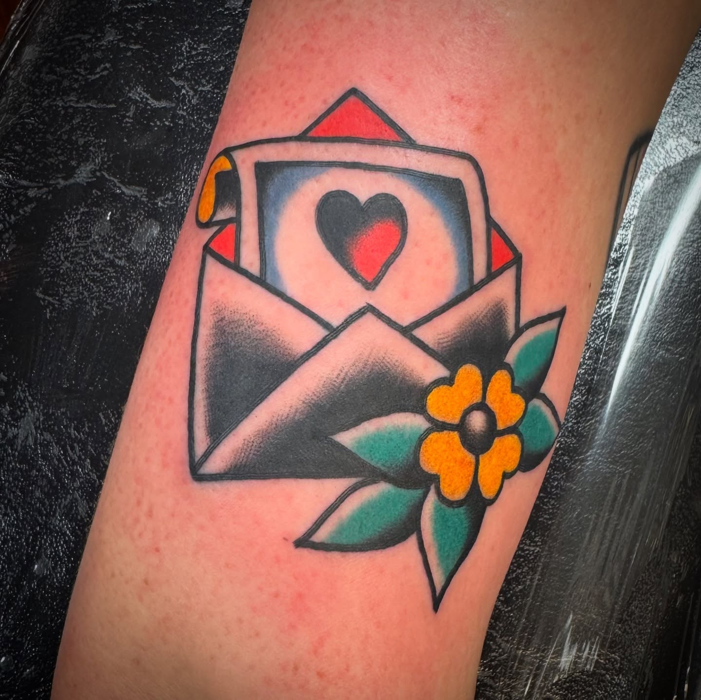 Envelope with heart American traditional tattoo on the forearm by Rogelio Robles