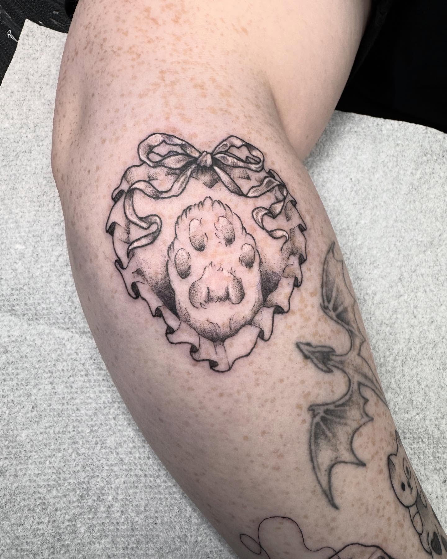 Skull with bow black and grey tattoo on the thigh by 𝔈𝔯𝔦𝔫 𝔊𝔦𝔩𝔩𝔦𝔩𝔞𝔫𝔡, Springfield, Ohio