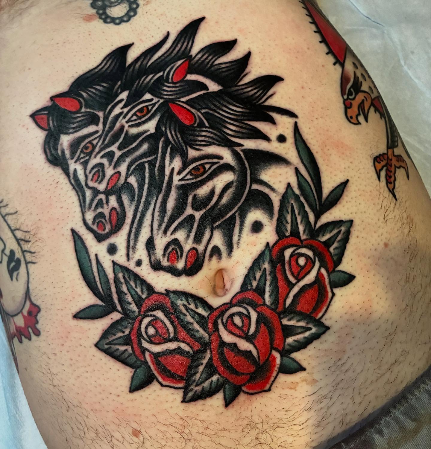 Zombie horse with roses American traditional tattoo on the shoulder by Mike Hudgins