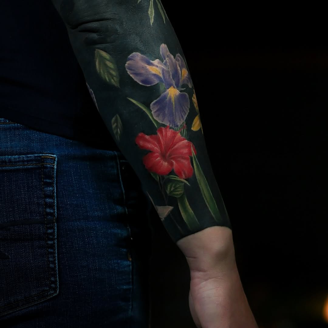 Flowers on black background watercolor tattoo on the forearm by Felipe Andrade